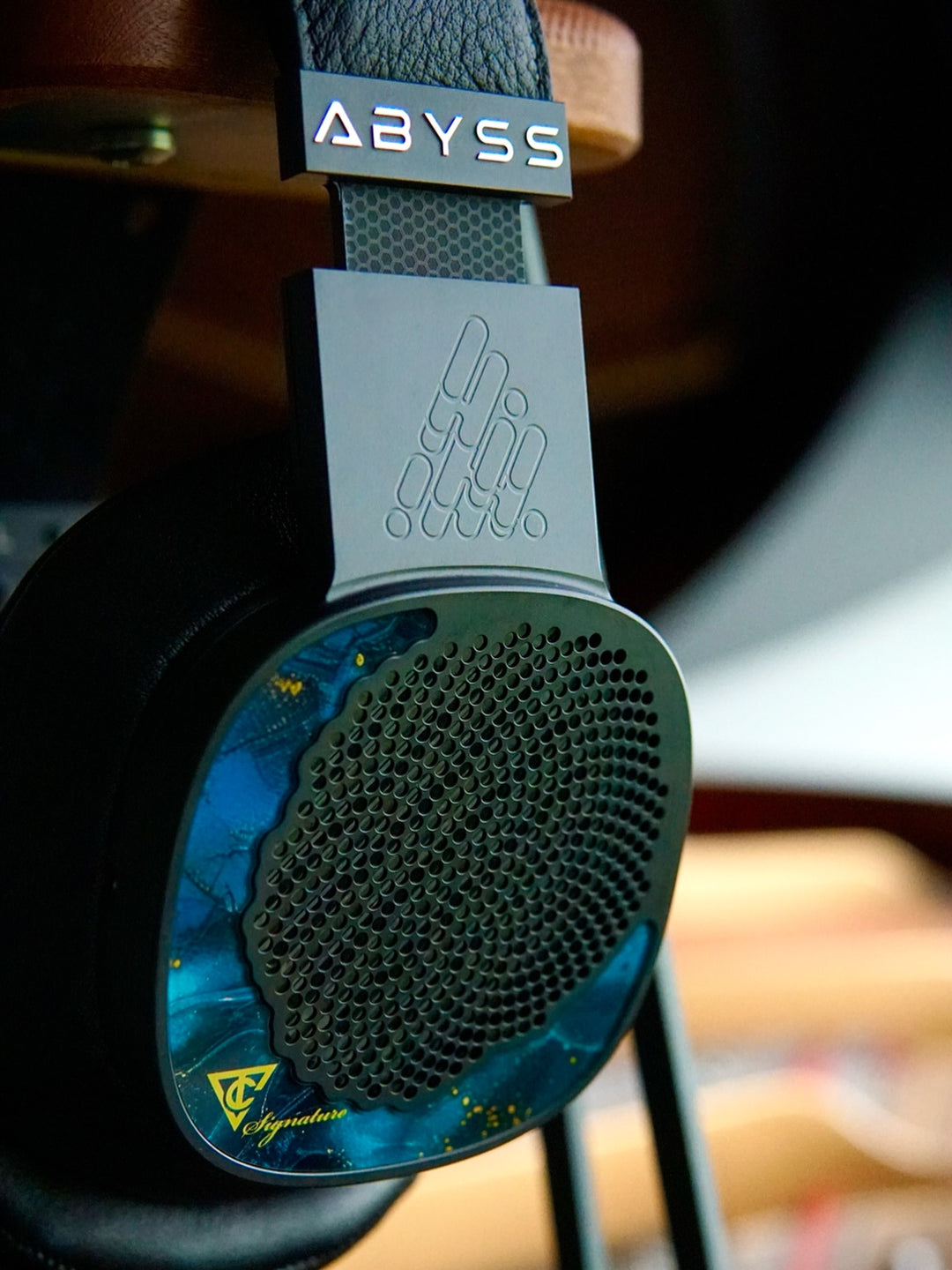 Close-up of a pair of headphones with 'Abyss' branding on a blurred background