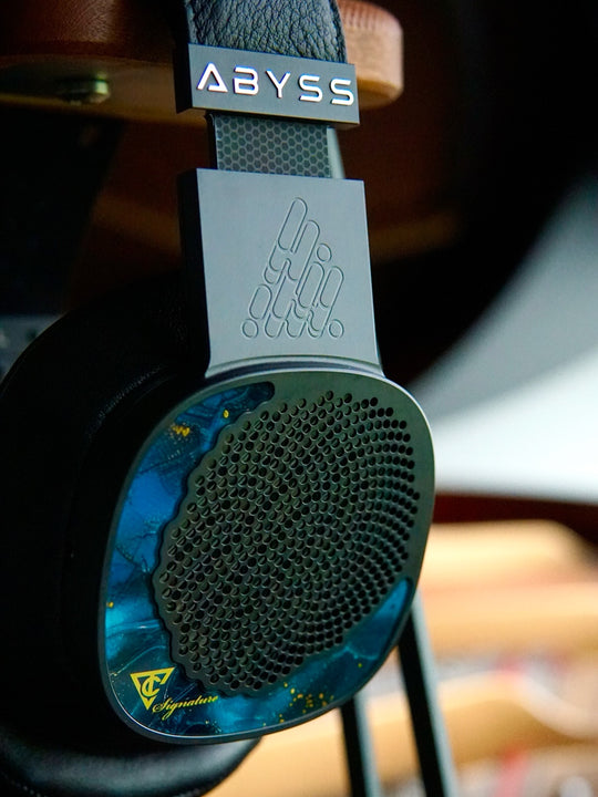 Close-up of a pair of headphones with 'Abyss' branding on a blurred background