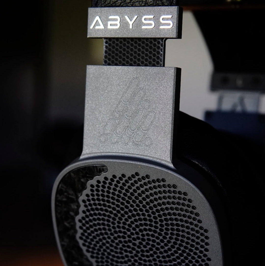 Close-up of a headphone with 'ABYSS' branding on a blurred background